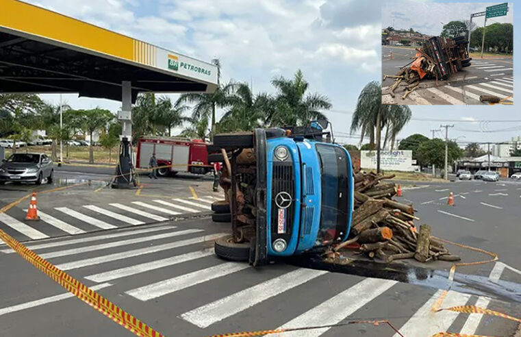 Caminhão carregado com troncos de árvore tomba em avenida