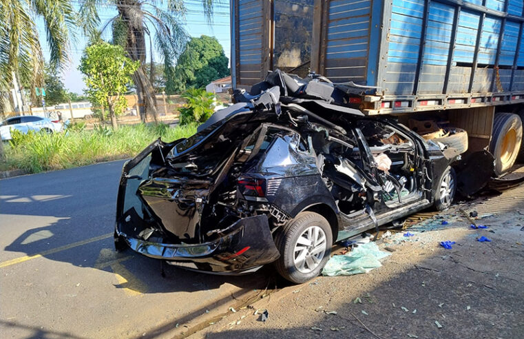 Carro tem perda total ao chocar em traseira de caminhão e motorista escapa da morte